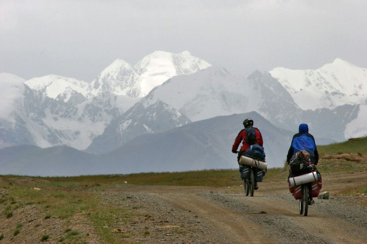 Deux voyageurs à vélo avec leurs sacoches sur une piste de montagne